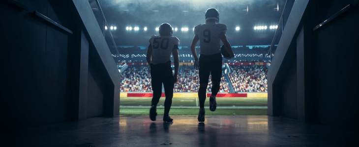 football players entering stadium field